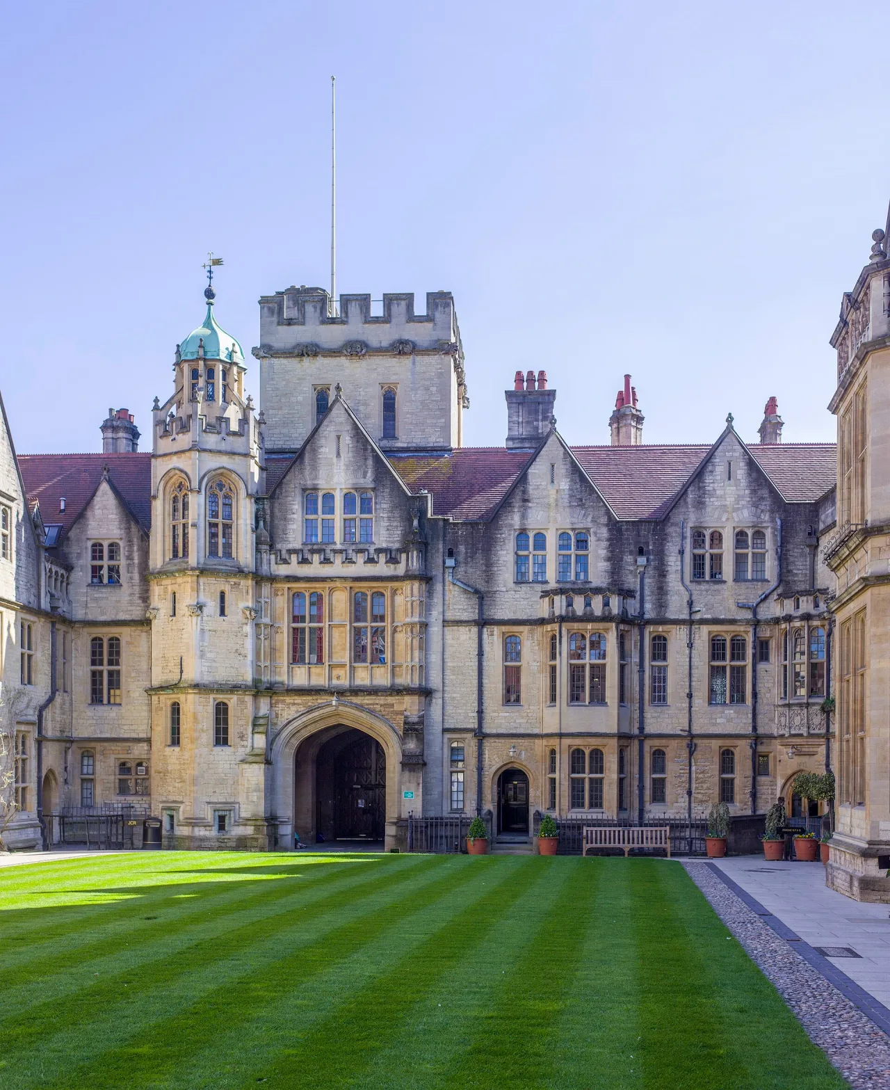 The stone front of Brasenose College in Oxford, with gabled windows, a gate tower and a striped green lawn in the foreground.