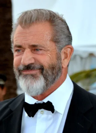 Head and shoulders photograph of an older man with swept-back grey hair and a grey beard, smiling slightly in a black dinner jacket and bow tie.