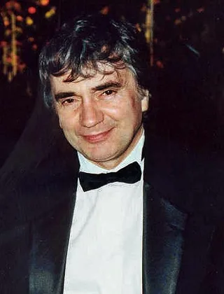 Head and shoulders photograph of a smiling dark-haired man in a black dinner jacket and bow tie, taken at an evening event.