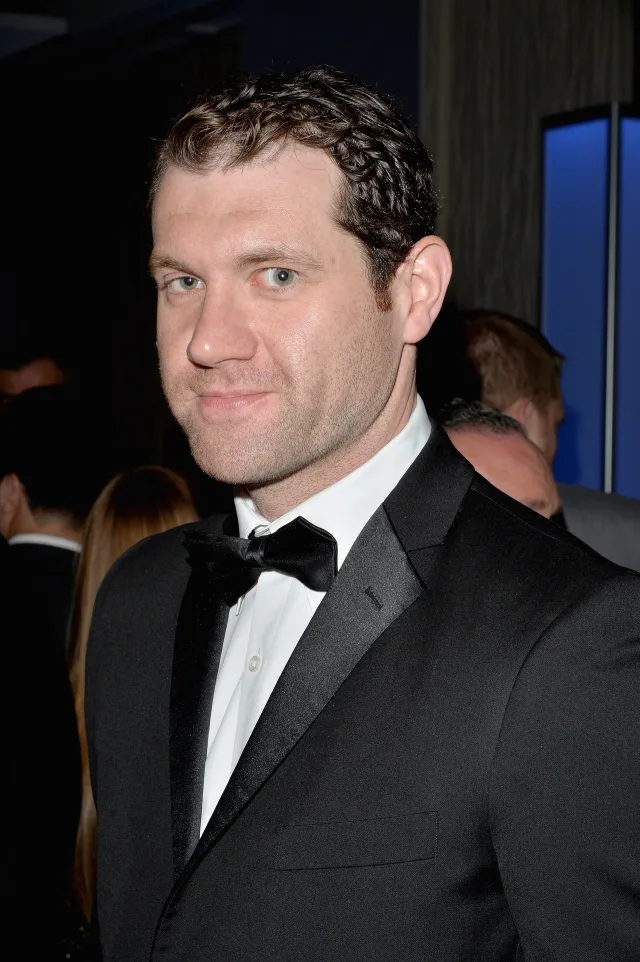 A man with short curly brown hair wearing a black tuxedo and bow tie at an evening event.