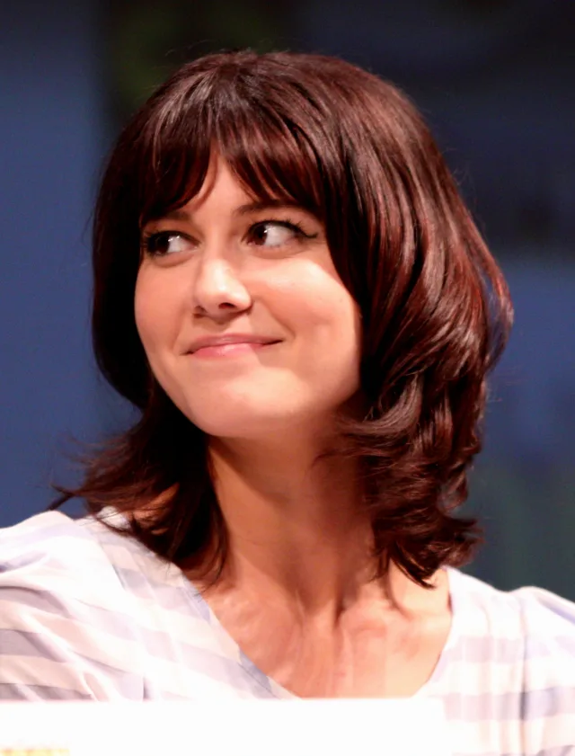 Close portrait of Mary Elizabeth Winstead with shoulder-length dark hair and a fringe, glancing sideways with a slight smile
