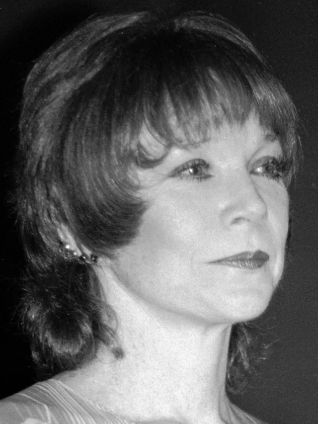 Black and white side-on portrait of a woman with a fringe and shoulder-length hair, wearing a small earring.