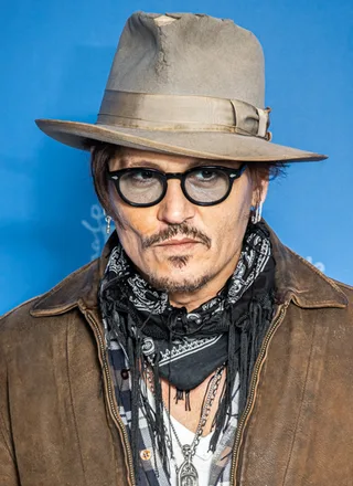 Johnny Depp photographed in 2020, smiling slightly at the camera.