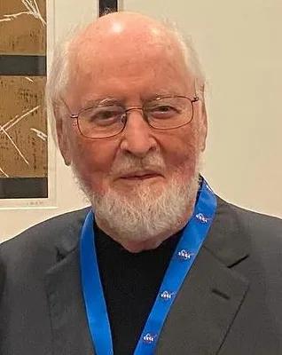 Composer John Williams in 2024, seated, in a dark jacket.