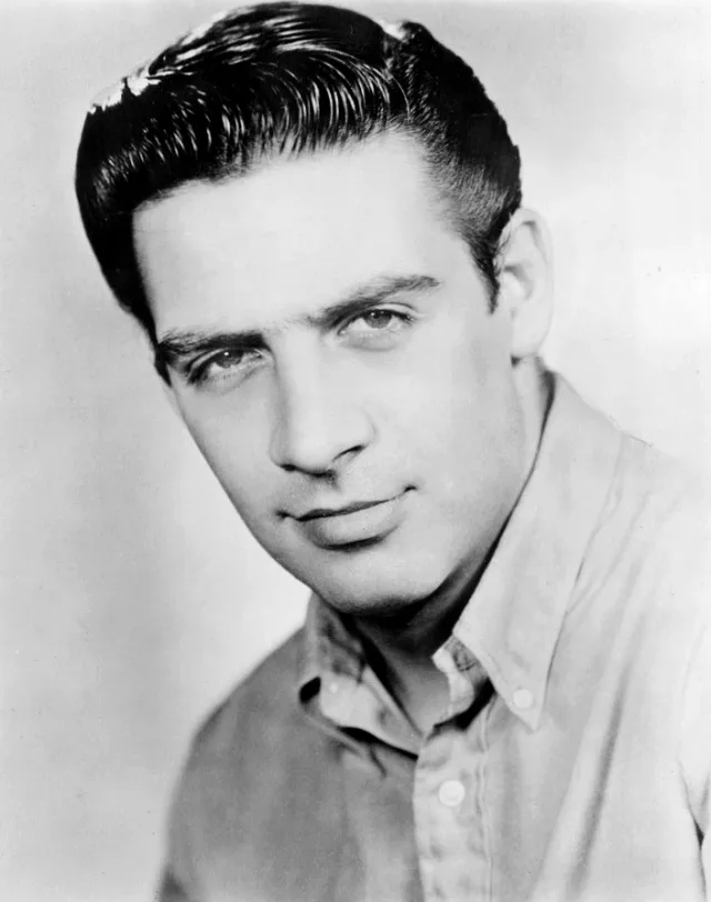 Black and white studio portrait of a young Jerry Orbach, a dark-haired man in an open-collared shirt, looking toward the camera.