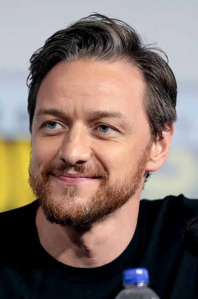 James McAvoy smiling at a panel event, wearing a dark jacket.