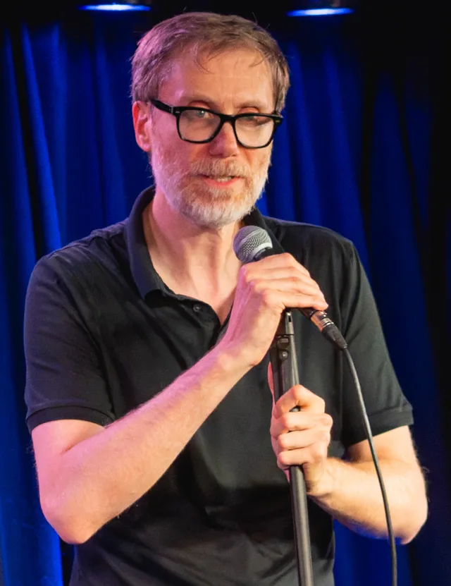 Head and shoulders photograph of Stephen Merchant, a tall man with short dark hair, taken at an event in 2025.