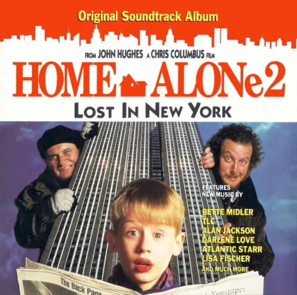 Soundtrack album cover with a red skyline banner, a startled boy in the foreground and two men peering round a tall skyscraper behind him.