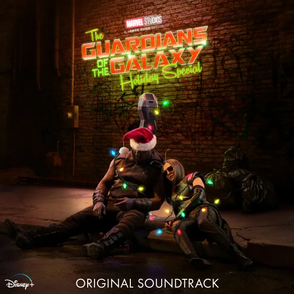 Two costumed figures slump on a kerb in a dark brick alley, tangled in coloured fairy lights, one wearing a Santa hat, beneath a glowing green and red neon title.